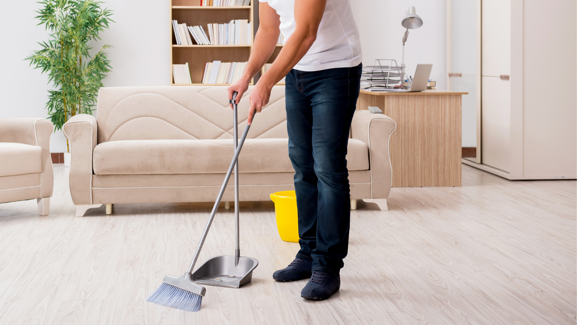Man using broom to sweep whitewashed LVP floors